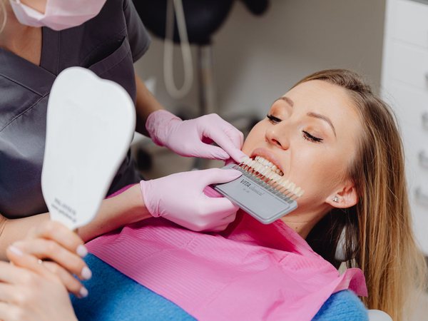 Paciente comprobando en un espejo el resultado de un tratamiento de estética dental